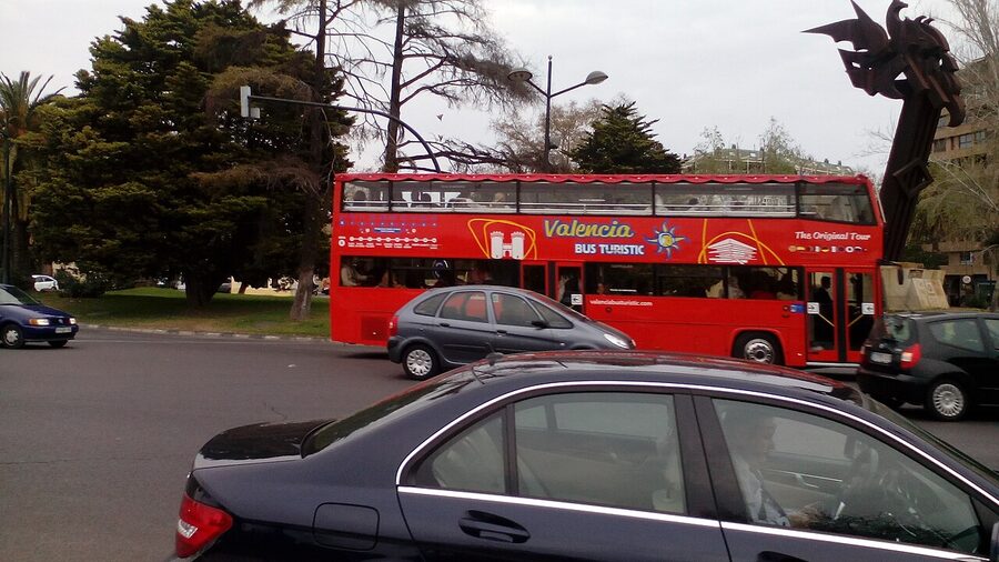 Red tourist bus parked near Valencia historic building