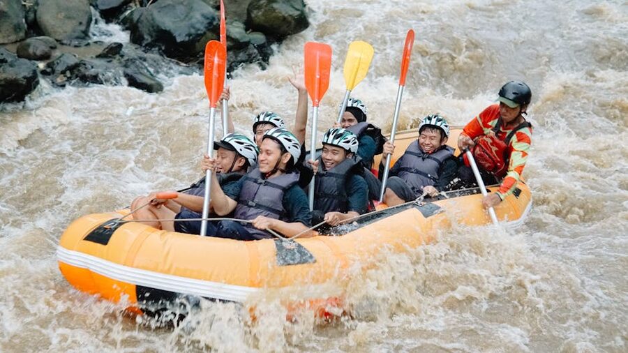 Group of rafters in a yellow raft going through whitewater rapids