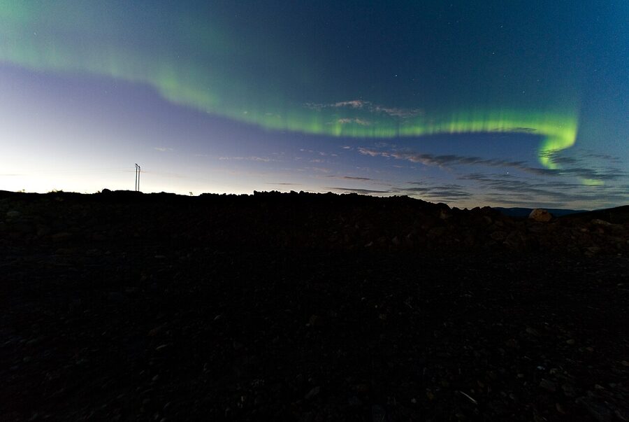 Aurora arching over the E10 highway near Katterjakk