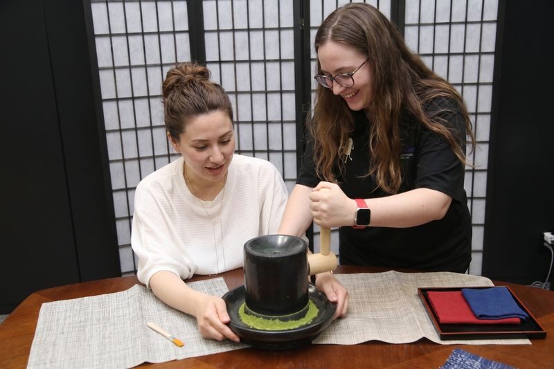 24K Gold & Washi: Design Your Unique Manekineko Workshop in Osaka - Grinding matcha on a stone mill